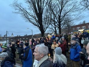 A crowd with candles gathers